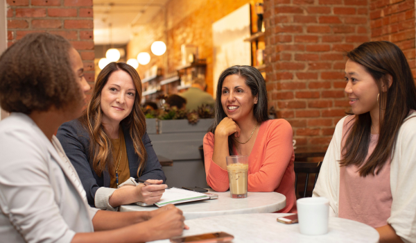 4 mujeres hablando de finanzas en una reunión